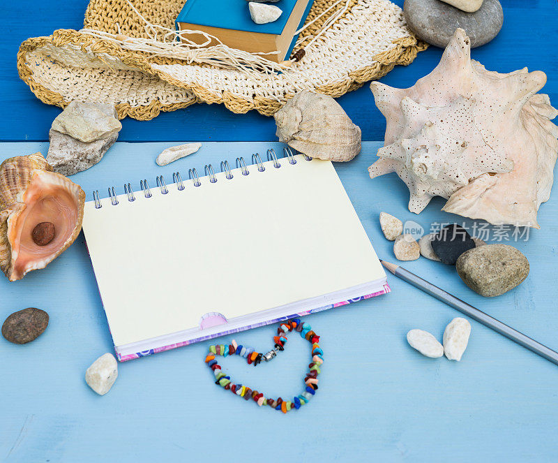 Sketchbook Mock up. Summer sea vacation mockup background. Notebook blank page mock-up with Travel and vacation items on blue wooden table. Sea shells, sea pebbles. Copy space